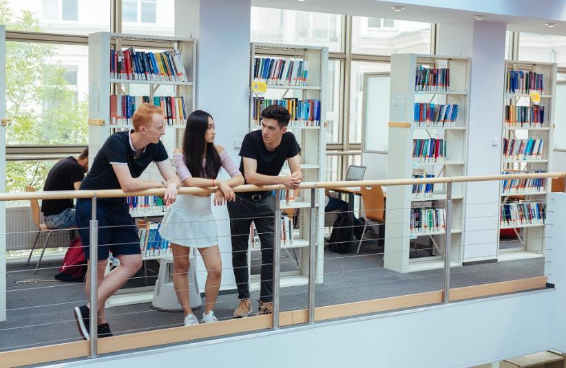 The photo shows a small group of people in a library.