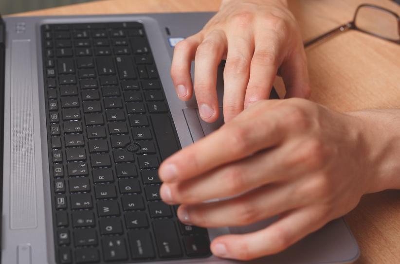 The photo shows hands on a keyboard