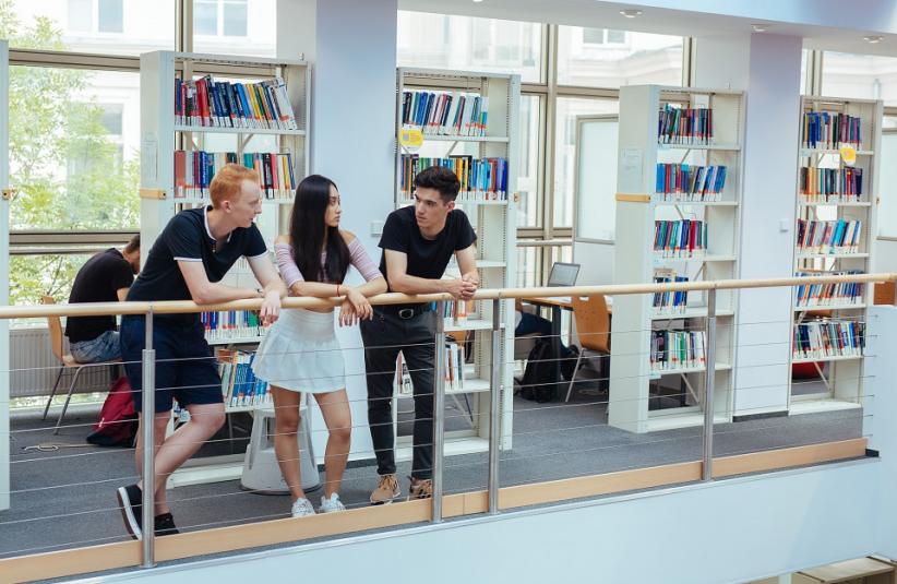 The photo shows 3 people in the library